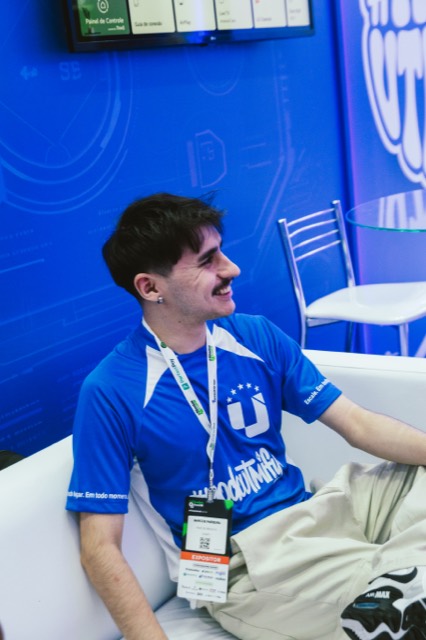 Cliente sorrindo no lounge do estande UTMify